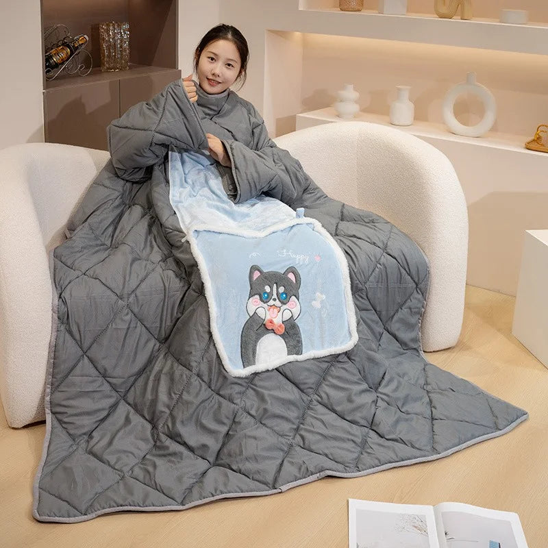 Person sitting on a couch under a large gray blanket with a cartoon cat design.