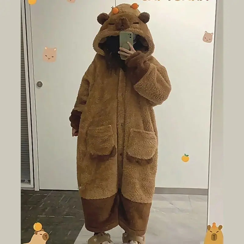 Person wearing a brown bear-themed onesie taking a mirror selfie.