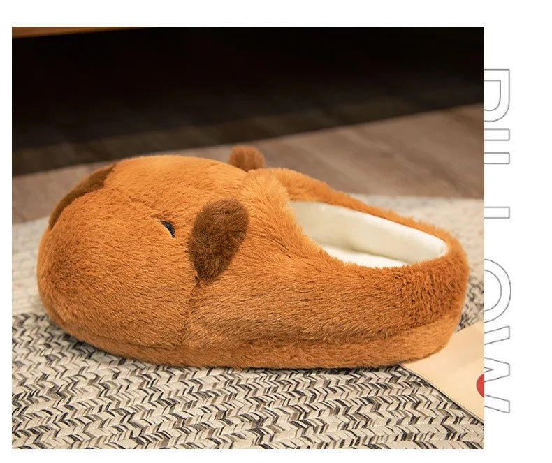 Brown plush slippers with a heart design on a textured surface