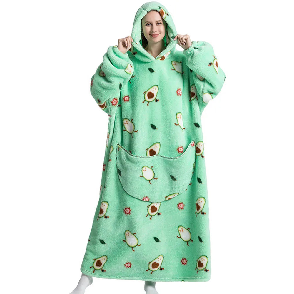 Person wearing a green avocado-patterned hooded blanket on a white background