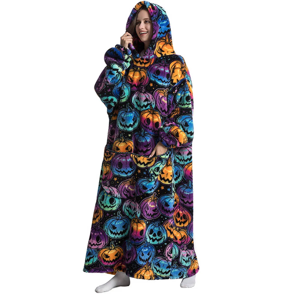 Person wearing a colorful Halloween-themed hooded blanket with pumpkins on a white background