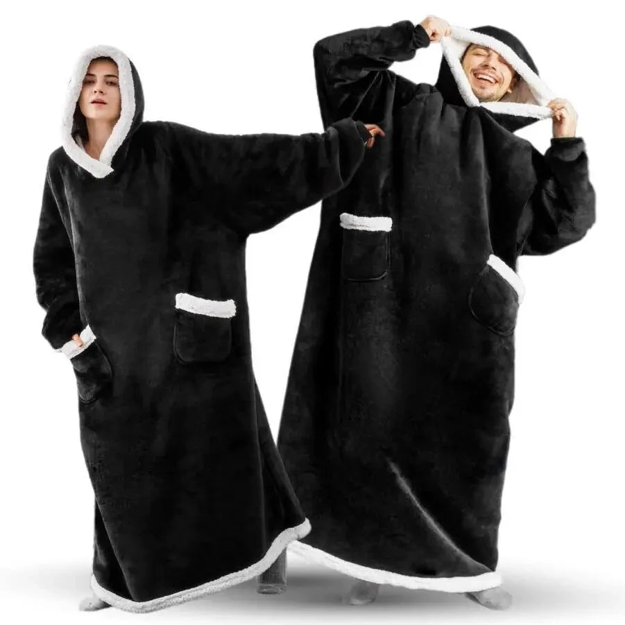 Two people wearing black hooded blankets with white trim on a white background