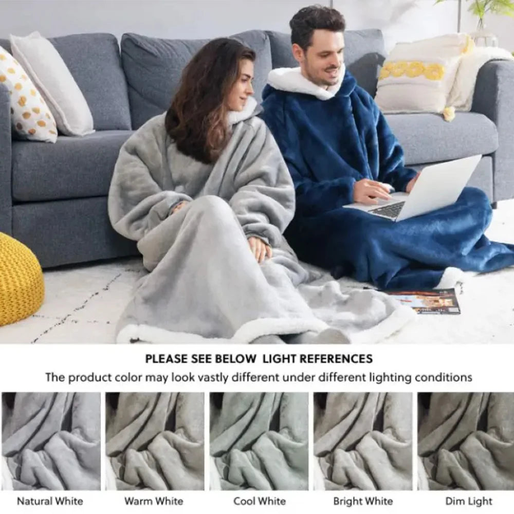 Two people sitting on a couch with oversized blankets, surrounded by light references for color accuracy.