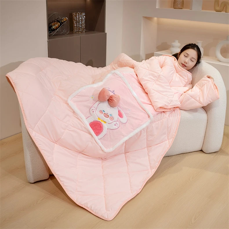 Person lying on a couch under a pink blanket with a cartoon pillow